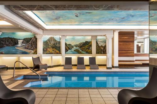 a pool in the lobby of a hotel with a painting at Hôtel Québec Best Western PLUS Centre-Ville - City Center in Quebec City