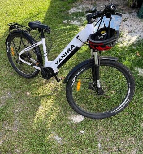 uma bicicleta estacionada na relva com um capacete em Tiny house et un vélo à assistance électrique (VAE) em Puahua