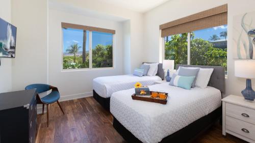 a bedroom with two beds and a desk and window at MAUNA KEA SUNSETS Gorgeous 2BR Kumulani Condo with Ocean Sunset View in Hapuna Beach