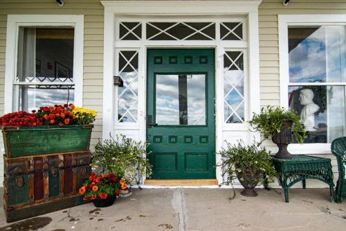 een groene deur op een huis met bloemen in een raam bij Ocean House Hotel & Motel in Old Orchard Beach