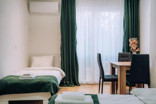 a bedroom with two beds and a table and a window at Darki Apartments 2 - Very Central Stay With Free Parking in Ohrid