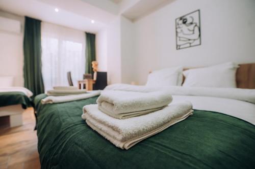 a green bed with white pillows on top of it at Darki Apartments 2 - Very Central Stay With Free Parking in Ohrid