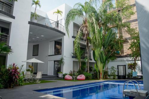 an apartment building with a swimming pool and palm trees at Almarea Vacation Condo in Playa del Carmen