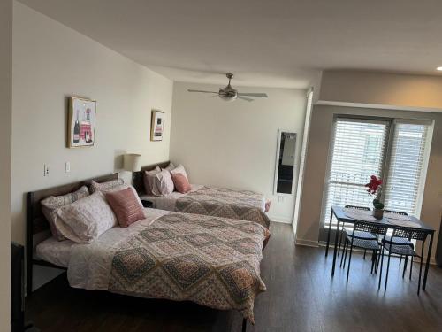 Un dormitorio con 2 camas y una mesa con una mesa. en Incredible Hollywood Loft Free Parking, en Los Ángeles
