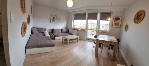 ein Wohnzimmer mit einem Sofa und einem Tisch in der Unterkunft Apple Apartments - Atlas Arena, Zoo, Fala, Mandoria, lotnisko, parking in Łódź
