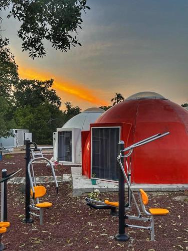 a red dome tent with some chairs in front of it at Iglú Popeye a 6 minutos de la paya in Barra de Navidad