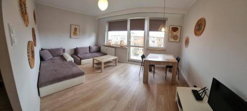 - un salon avec un canapé et une table dans l'établissement Apple Apartments - Atlas Arena, Zoo, Fala, Mandoria, lotnisko, parking, à Łódź