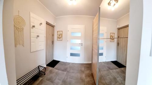 un couloir vide avec une porte en verre dans une chambre dans l'établissement Apple Apartments - Atlas Arena, Zoo, Fala, Mandoria, lotnisko, parking, à Łódź