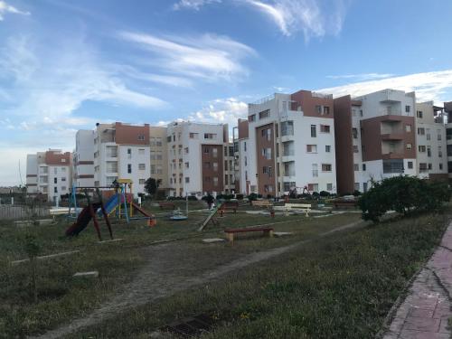 un parque con parque infantil frente a los edificios en Appartement Familial en face la plage Haouara Tanger, en Tánger