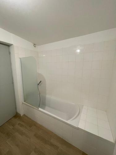 uma banheira branca com um espelho na casa de banho em Charmante Maison 3 Chambres Plein Centre avec Parking Privé Gratuit em Lorient