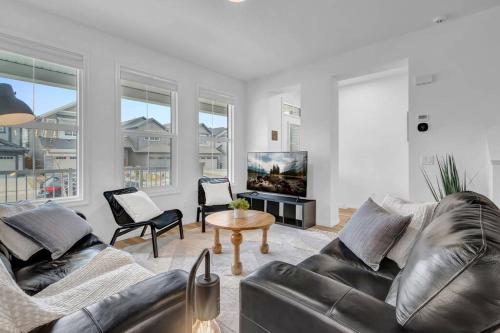a living room with two leather couches and a tv at LovelyHome-Foosball-NearAirport-5 Queen Beds -Air conditioning in Edmonton