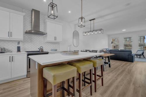 a kitchen with a large island with yellow bar stools at LovelyHome-Foosball-NearAirport-5 Queen Beds -Air conditioning in Edmonton