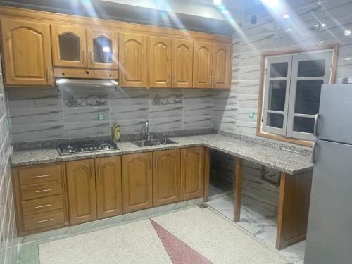 a kitchen with wooden cabinets and a refrigerator at Chez azrou in Azrou