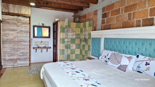 a bedroom with a bed and a brick wall at Villa Linda ApartaHotel in Jericó