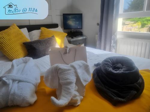 a bedroom with a bed with towels on it at Lovely 1-Bed Studio Annex, Hampton, free parking in Hampton Hill
