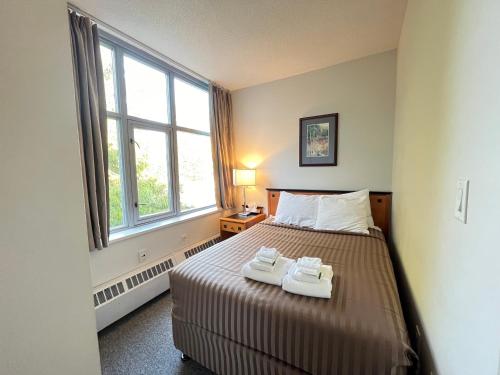 a bedroom with a bed with two towels on it at Carey Centre on UBC campus in Vancouver