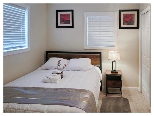 a bedroom with a large white bed and two windows at Modern Comfort Stays in Alexandria