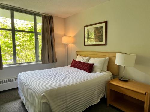 a bedroom with a large bed with a red pillow at Carey Centre on UBC campus in Vancouver