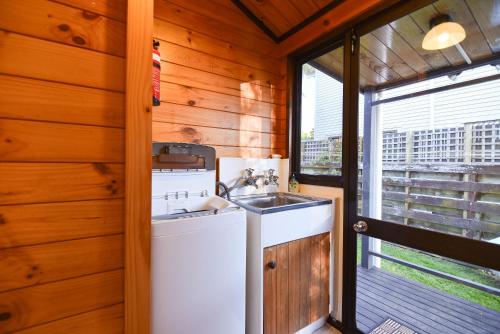 una cucina con lavandino e lavatrice di Cooper's Lakeside Cabin a Rotorua