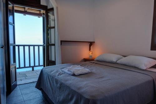 a bedroom with a bed and a large window at Hideaway in Damouchari with private access to sea ANNA's HORIZON in Damouchari