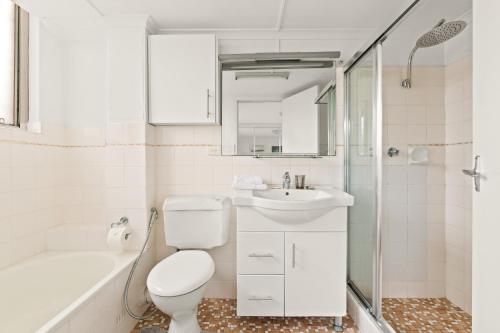 e bagno con servizi igienici, lavandino e doccia. di Large 1-Bed with Swimming Pool in Iconic Bondi a Sydney