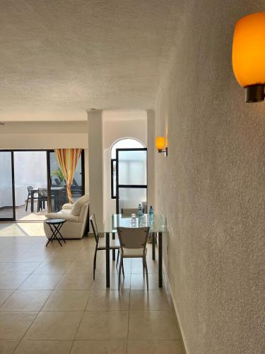 a dining room with a table and a couch at Pelicano Inn Playa del Carmen - Beachfront Hotel in Playa del Carmen
