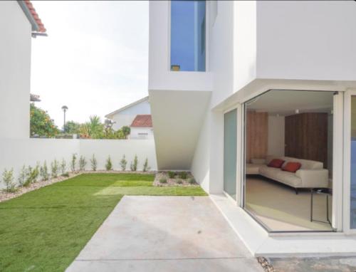 a modern house with a green lawn at Villa Emerald Oeiras Lisbon in Oeiras