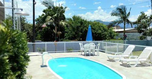 a patio with a pool and chairs and a table at Recanto Munik in Palhoça