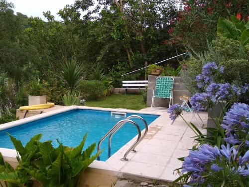 una piscina en un jardín con flores en CABAÑA LA MATILDE en Río Ceballos
