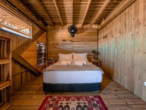a bedroom with a bed in a wooden cabin at Watu Kite House in Mayapo