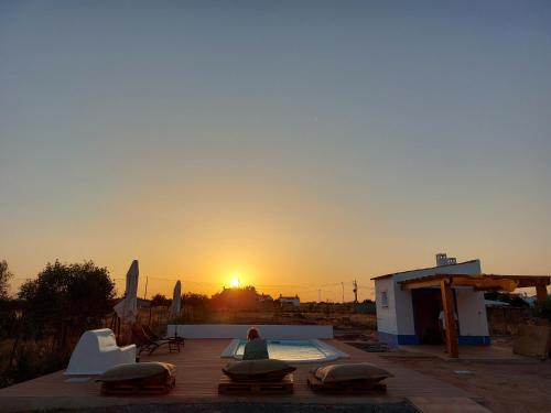 a person sitting on a patio watching the sunset at Casa Com Vagar in Campinho