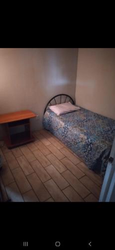a small bedroom with a bed and a table at S&M Apartments and rooms in San José