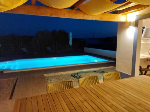 a swimming pool in a room with a table and chairs at Casa Com Vagar in Campinho