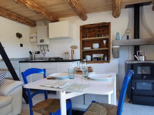 une cuisine avec une table blanche et des chaises bleues dans l'établissement Maison de vigne rénovée à Langeac, nature et randonnées - FR-1-582-86, à Langeac