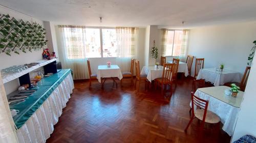 Ayma Hostel Puno في بونو: غرفة طعام مع طاولتين وطاولتين بيضاء