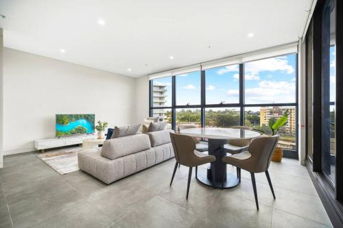 a living room with a couch and a table and chairs at Spacious 2Bedroom Apt in Homebush in Sydney