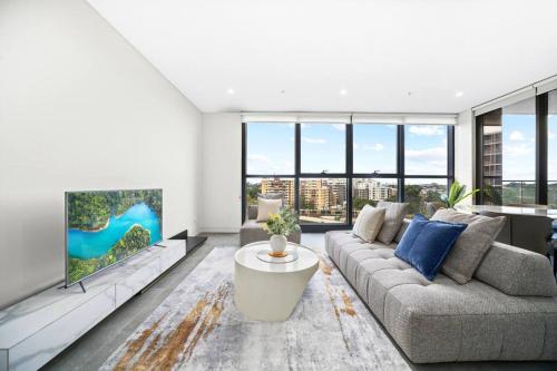 a living room with a couch and a tv at Spacious 2Bedroom Apt in Homebush in Sydney