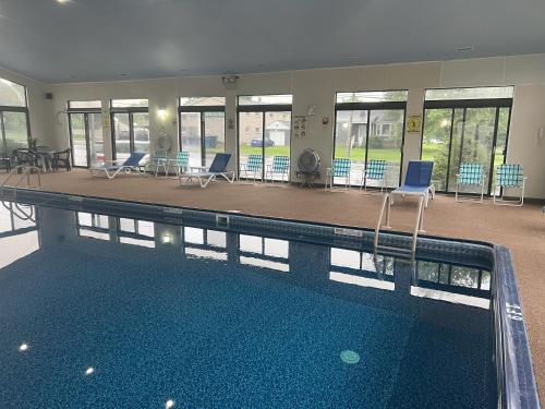 a large swimming pool with chairs and tables in a building at Travelodge by Wyndham Hershey in Hershey