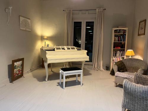 a white piano in a living room with a table at Escape to the country - Casa de Lorenzo, El Hierro in San Andrés