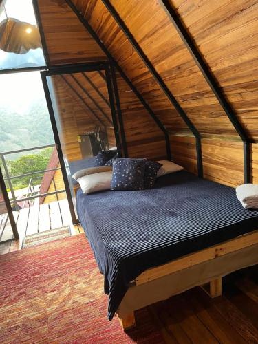 Bett in einem Zimmer mit Holzdecke in der Unterkunft Club Glamping Villa Luz in Chinácota