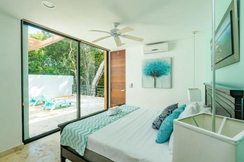 a bedroom with a bed and a large window at LUXE 1-BR Condo in Bahia Principe - Multiple Pools in Akumal