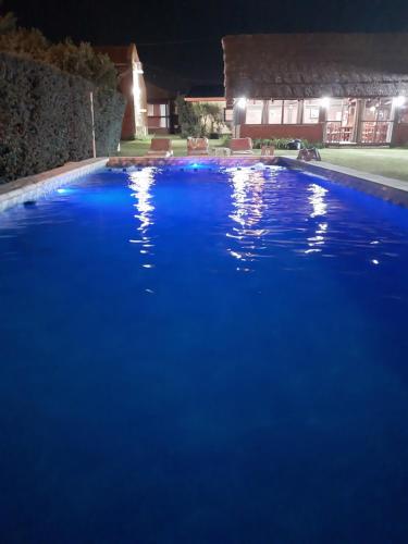 a large pool of blue water at night at Complejo Cantonavi in Mina Clavero