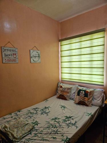 a bedroom with a bed and a window with a window blind at Mel's Place Batangas Unit 2 Two Bedroom House w Free Parking WIFI Smart TV Netflix Hot & Cold Shower in Batangas City