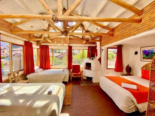 a bedroom with three beds and a fireplace in it at Hostal Madre Tierra in Cusco