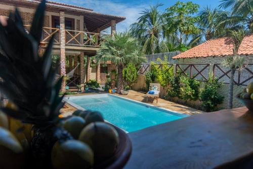 a villa with a swimming pool in front of a house at Casa do velejador in Barra Grande