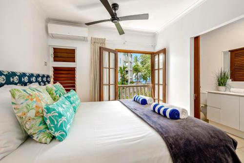 a bedroom with a large white bed with blue pillows at Palm Cove Beach Retreat - 1st Floor in Palm Cove