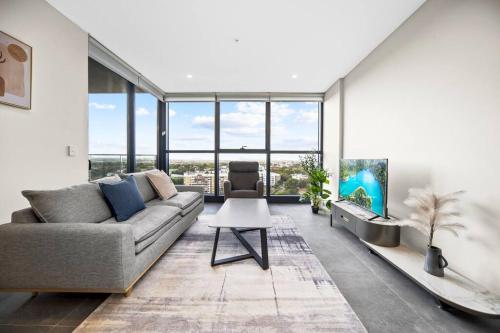 a living room with a couch and a table at City&Bridge View 2 Bed+Study in Homebush in Sydney