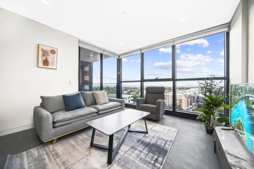 a living room with a couch and a table at City&Bridge View 2 Bed+Study in Homebush in Sydney