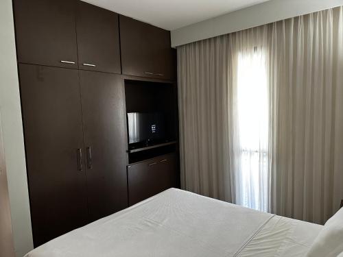 ブラジリアにあるHotel Bonaparte Flat Particular Cのベッドルーム1室(ベッド1台、電子レンジ、窓付)