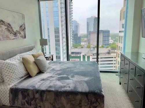 a bedroom with a bed and a large window at Ruby Getaway-Highrise, Balcony, Pool, City View! in Atlanta